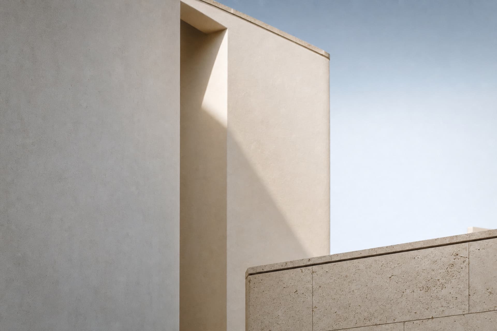 Façade contemporaine en enduit clair, une embrasure profonde projetant une ombre oblique sous un ciel dégagé